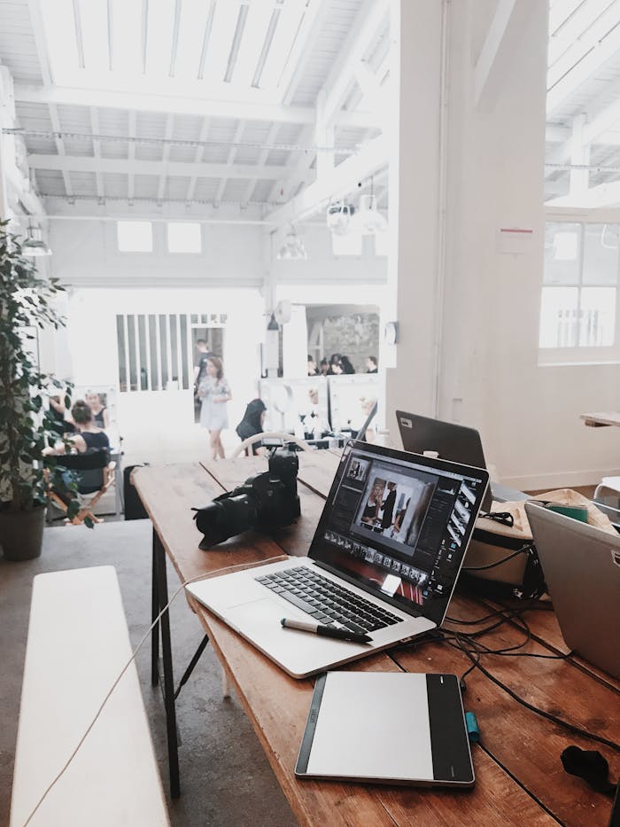 Mastering the First Impression: Your intriguing post title goes here A bright, modern workspace featuring laptops, a camera, and a drawing tablet in an indoor office.