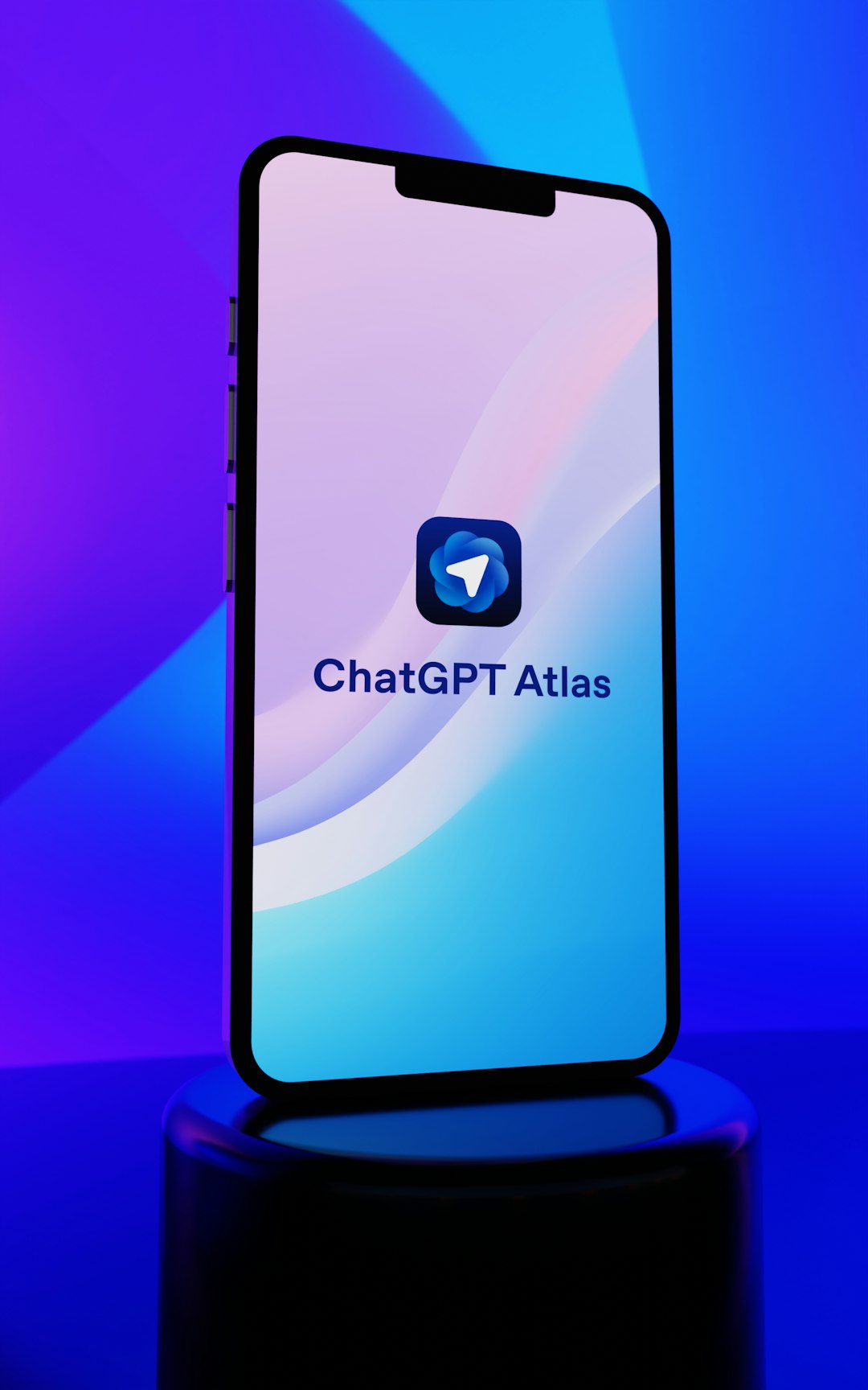 ChatGPT Atlas app displayed on a modern smartphone with sleek gradient background blending vibrant purple, blue, and cyan colors. The minimalist interface showcases the distinctive blue messenger-style icon and app branding on a device with dynamic island design. Perfect representation of cutting-edge AI technology, mobile applications, and contemporary digital innovation in artificial intelligence communication tools.